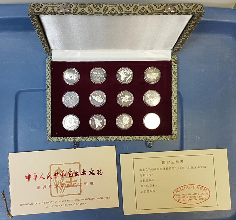 Case open showing medallions with certificates in front.