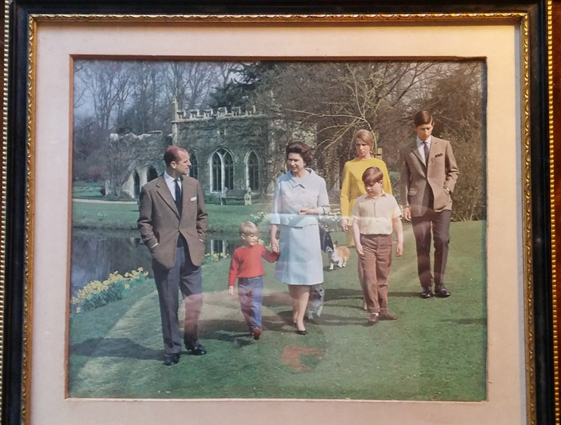 Colour photograph of royal family, behind glass of frame